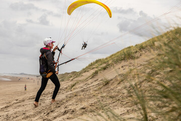 woman flying paraglider in Netherlands dunes