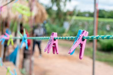 The clothespin is made of colorful plastic that is attached to the clothesline.