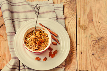 Fruits and nuts crumble pie in a portion form and a dessert spoon. Dessert with oatmeal, almonds and cinnamon  on wooden table, selective focus. Top view