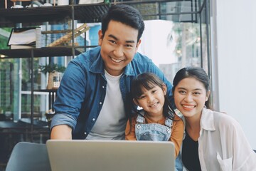 Obraz premium Happy family using laptop together at living room,Parents watching movie with child.