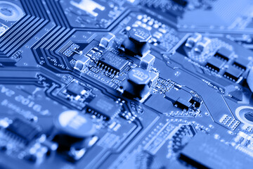 Electronic circuit board close up. Blue background.