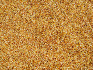 Abstract background with golden sand showing a fine texture and detail, sparkling colors created by the small shells, crystals and silica particles, top view, flat lay perspective with copy space