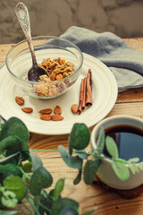 Fruits and nuts crumble pie server in a glass bowl and cup of black tea or coffee on a wooden table. Healthy dessert or morning breakfast concept. Selective focus