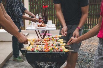 Men grilling pork and barbecue in dinner party. Food, people and family time concept.