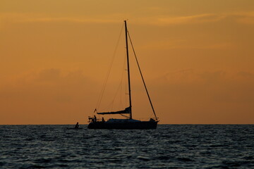 A sailboat on the sea at sunset