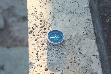 compass on a stone at the top of a mountain