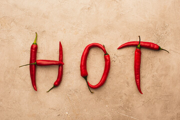 top view of word hot made of chili peppers on beige concrete surface - Powered by Adobe