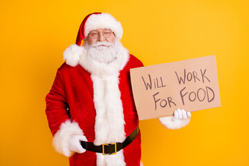 Portrait of his he nice serious fired white-haired Santa holding in hands paper card promo will work for food industry reduction isolated bright vivid shine vibrant yellow color background