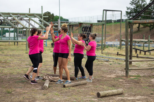 Group of woman high fiving each other at boot camp