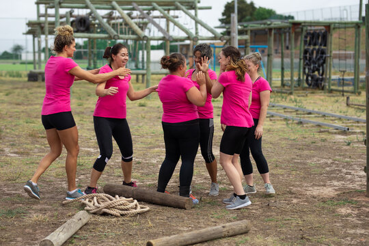 Group of woman high fiving each other at boot camp