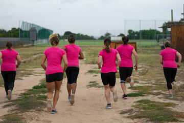 Rear view of group of woman running at boot camp