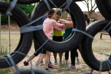 Group of woman stacking hands together at boot camp