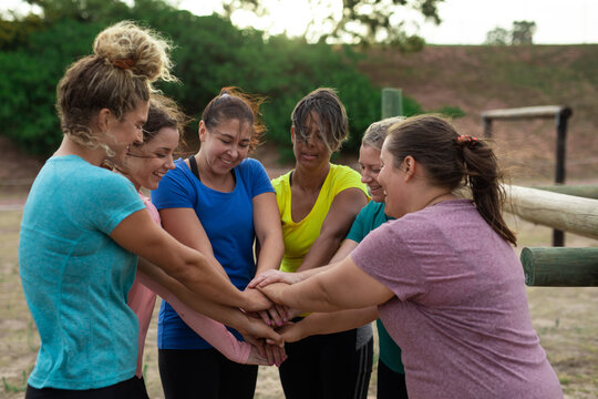 Group of woman stacking hands together at boot camp