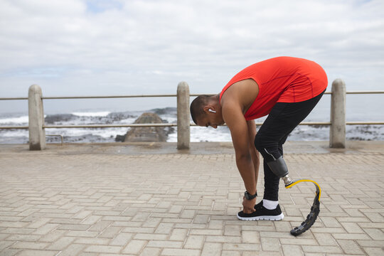 Black African American Man with prosthetic leg tying his shoe laces - Powered by Adobe