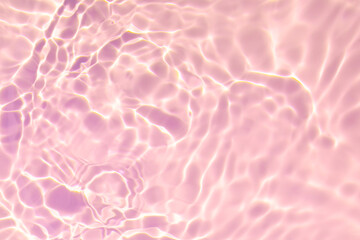 Closeup of pink transparent clear calm water surface texture with splashes and bubbles. Trendy abstract summer nature background. Coral colored waves in sunlight. Copy space.