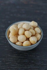 macadamian nuts on dark wooden surface