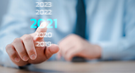 New year 2020 change to 2021 concept, hand touching on 2021 virtual screen.