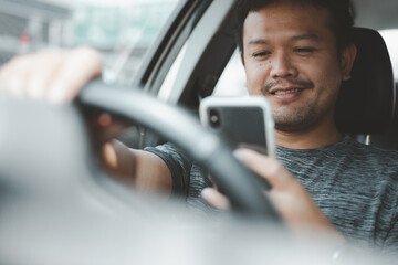 Asian man video calling via smart mobile phone inside a car, close up. People lifestyle, social...