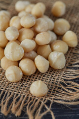 macadamian nuts on dark wooden surface