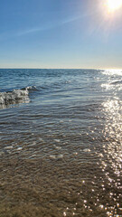 Seascape. Azure color of water, waves foaming on the shore. Selective focus. Summer rest.