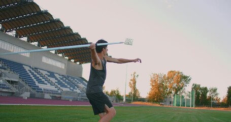 A male athlete throws javelins at a stadium in slow motion. Athletics javelin throw Olympic program - Powered by Adobe