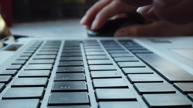 Young business woman is using her laptop computer and writing an email in slow motion. Close up of a slow motion video of a woman using laptop. Business concept. 