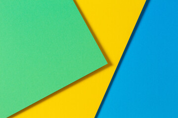 Abstract color papers geometry flat lay composition background with blue, yellow and green color...