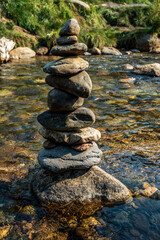 balanced Zen rocks art stacked in flowing water stream
