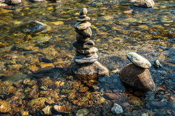 Fototapeta na wymiar balanced Zen rocks art stacked in flowing water stream