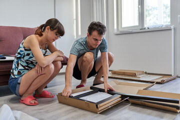 Young couple assembling their furniture