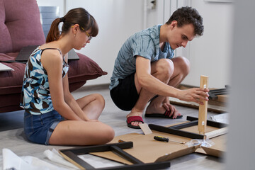 Young couple assembling their furniture