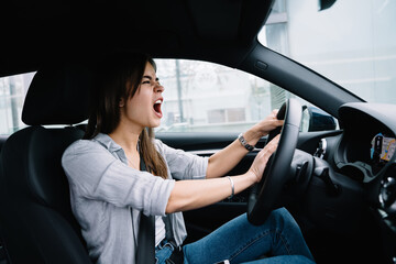 Fototapeta na wymiar Angry young woman driving car