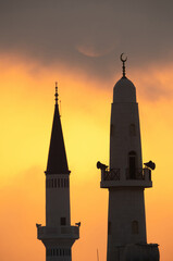 Obraz premium Minarets and the sun in the morning, a view from Busiateen coast, Bahrain
