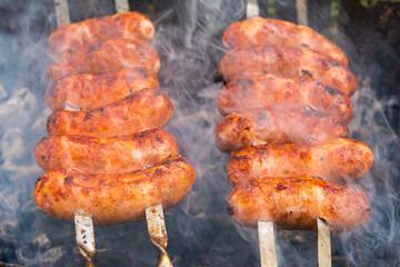 skewered pork sausages with a fried crust, grilled, food cooked in the open air close-up