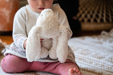 Child playing with a stuffed animal bunny toy