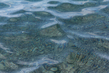 Sea stones in the sea water. Pebbles under water. The view from the top. Nautical background. Clean sea water. Transparent sea.