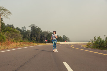 Obraz premium Woman running on the road. Jungle landscape. Concept of health and sport.