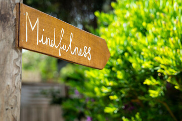 Sign saying mindfulness outside green bushes