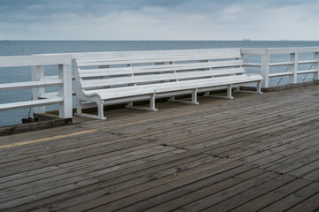 Fototapeta na wymiar Empty bench on wooden boardwalk at seashore