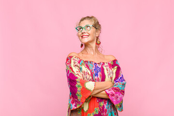 middle age woman feeling happy, proud and hopeful, wondering or thinking, looking up to copy space...