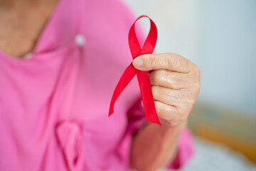 Breast cancer, pink ribbon at Asian senior lady patient for supporting awareness.
