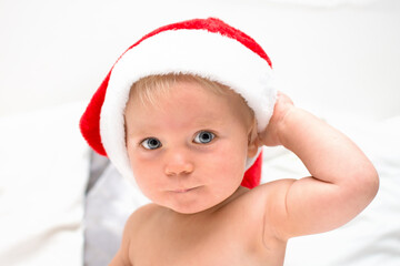 Little baby boy smiling face with red santa hat. One year old kid in christmas costume, christmas time concept