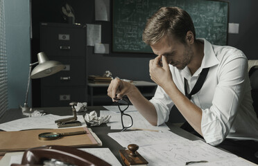 Math student sitting at desk and reviewing his papers