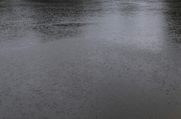 Abstract background, rain drops on the water, rain on the lake.
