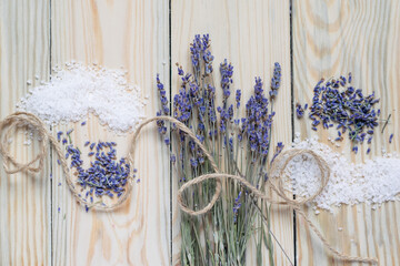 Bunch of dried lavender and sea salt on wooden background. Top view.
