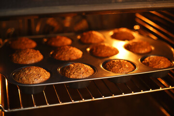 Baked muffins in a metal pan in the oven.