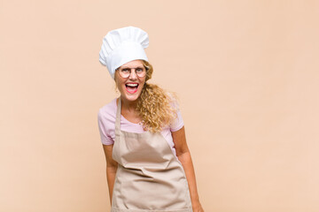 middle age woman baker with a big, friendly, carefree smile, looking positive, relaxed and happy,...