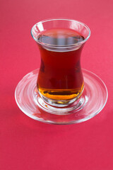Turkish tea in the glass on the red  background closeup