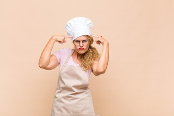 middle age woman baker with a serious and concentrated look, brainstorming and thinking about a challenging problem