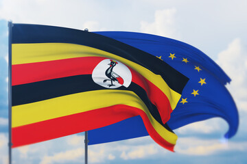 Waving European Union flag and flag of Uganda. Closeup view, 3D illustration.